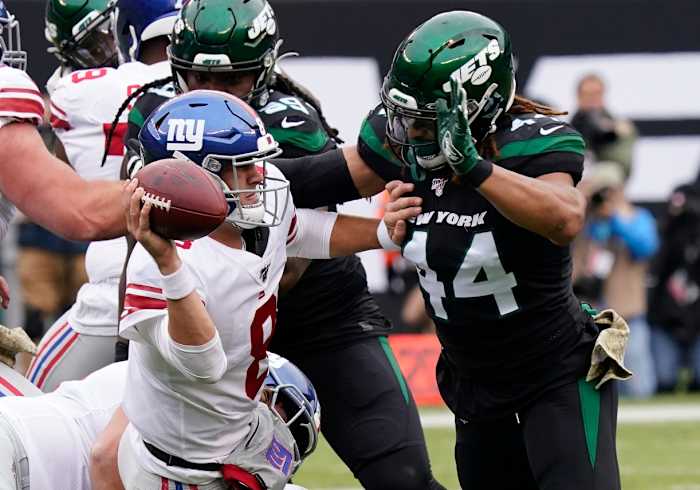 Nov 10, 2019; East Rutherford, NJ, USA; New York Giants quarterback Daniel Jones (8) barely gets the ball off under pressure from New York Jets linebacker Harvey Langi (44) at MetLife Stadium.